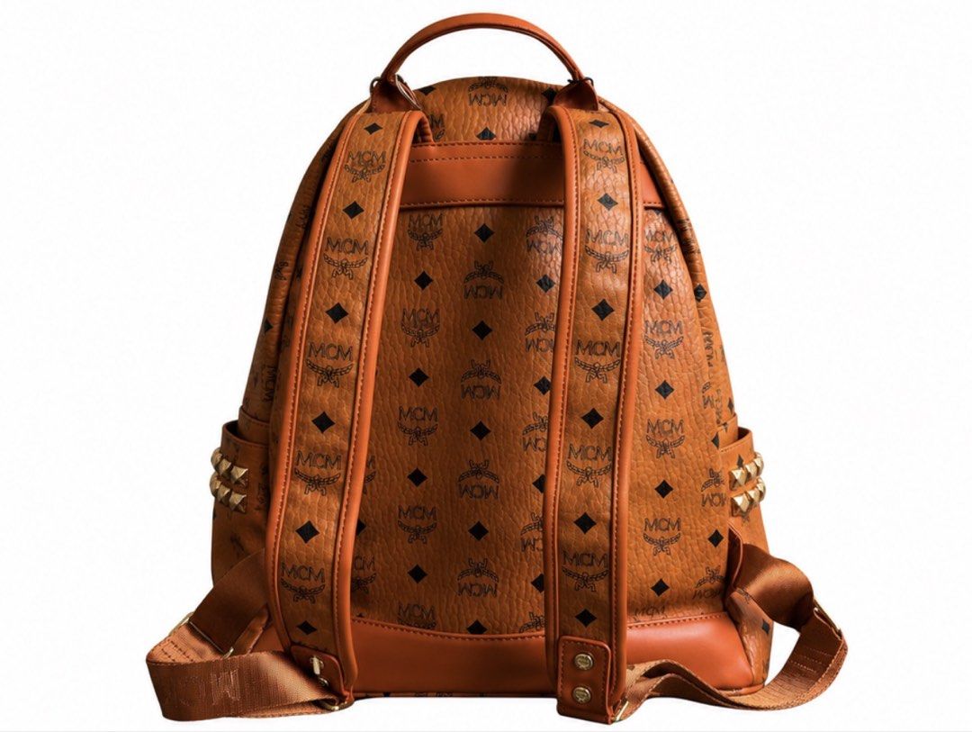 MCM Visetos Monogram Studded Leather Backpack Cognac (Category: Luxury Bags & Wallets) located in Manila. Submitted by dough_lux (Listing ID 1468959502, Image 2). Description: - Brand: MCM - Color: Cognac brown with classic monogram print - Material: Premium leather - Hardware: Gold-toned - Compartments: Front zippered pocket, interior zip pocket, spacious fabric-lined main interior - Features: Signature studded side pockets, adjustable shoulder 