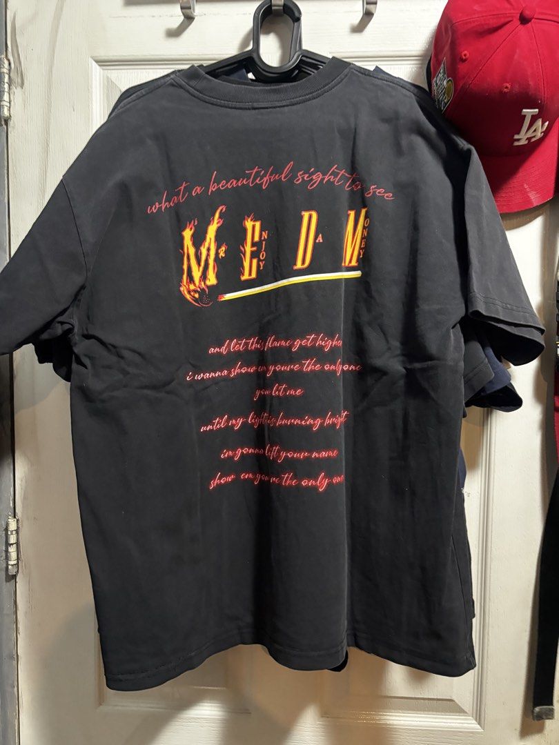 M.E.D.M Black Flame Graphic T-Shirt (Category: Tshirts & Polo Shirts ) located in Quezon City. Submitted by .sachii_ (Listing ID 1469023604, Image 2). Description: - Brand: M.E.D.M (Mr. Enjoy Da Money) - Color: Black with red and yellow flame chest lettering - Design: Large graphic print and lyrics on the back - Material: Premium heavy cotton for durability - Fit: Regular fit, short sleeves, classic crew neck - Style: Everyday streetwear - Condit