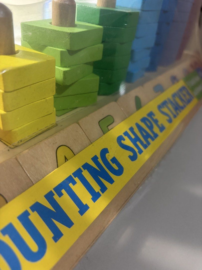 Melissa & Doug Counting Shape Stacker Wooden Toy (Category: Educational & Learning Toys) located in Quezon City. Submitted by KRC07 (Listing ID 1469054299, Image 2). Description: - Brand: Melissa & Doug Classic Toy Counting Shape Stacker - Condition: Brand new, still sealed in original plastic packaging - Materials: Durable wooden base with pegs and colorful wooden shapes - Shapes included: Circles, triangles, squares, and rectangles - Colors: Or