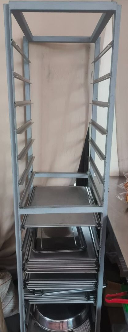Metal Baking Tray Rack with Multiple Shelves (Category: Bakeware) located in Calamba. Submitted by scarlette7 (Listing ID 1468932708, Image 1). Description: - Heavy-duty tall metal baking rack with sturdy grey painted frame - Features multiple convenient slide-in tray slots - Includes several stainless steel trays stacked near the bottom - Maximizes vertical space efficiently - Perfect for both home and commercial kitchens.