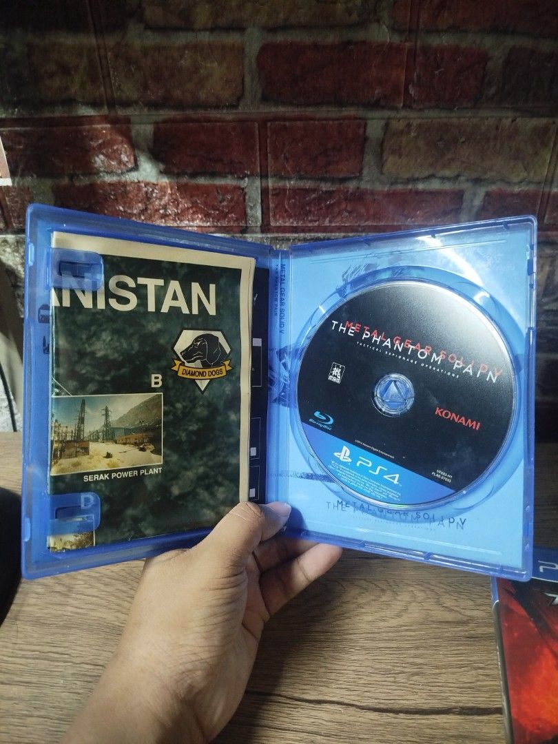 (With Map) Metal Gear Solid V The Phantom Pain PS4 Game (Category: PlayStation) located in Binan City. Submitted by pumpkiiin02 (Listing ID 1468991488, Image 3). Description: - Title: Metal Gear Solid V The Phantom Pain - Platform: PlayStation 4 (PS4) - Publisher: Konami - Genre: Tactical Espionage Action - Inclusions: Original blue case, game disc, and map insert manual - Region: Asia / English compatible - Condition: Clean disc surface, case cl