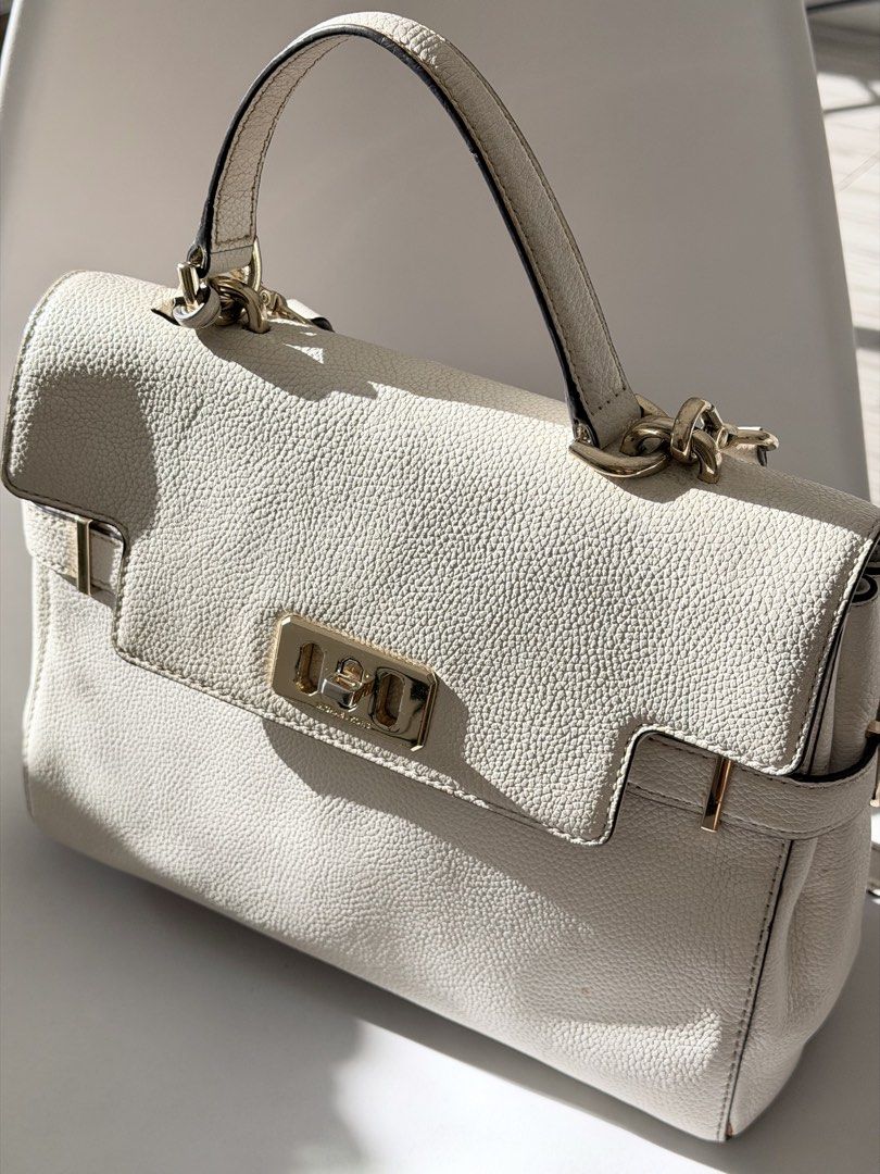 Michael Kors Karson Satchel White Handbag (Category: Luxury Bags & Wallets) located in Quezon City. Submitted by angelpadilla (Listing ID 1469029103, Image 1). Description: - Brand: Michael Kors Karson - Material: White pebble leather with gold-tone hardware - Closure: Signature turn-lock on front flap - Straps: Top handle and removable shoulder strap with logo charm - Condition: Shows minor signs of usage on leather and hardware, but still holds
