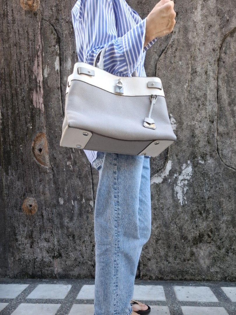 Michael Kors Two-Tone Leather Tote Bag Grey White (Category: Tote Bags) located in Makati City. Submitted by itemsforless2025 (Listing ID 1469036770, Image 2). Description: - Brand: Michael Kors - Style: Structured tote bag - Material: Grey and white textured leather - Hardware: Silver-tone with signature front padlock - Features: Double top handles, attached leather luggage tag, clean interior lining with pockets - Size: Standard medium, spaciou