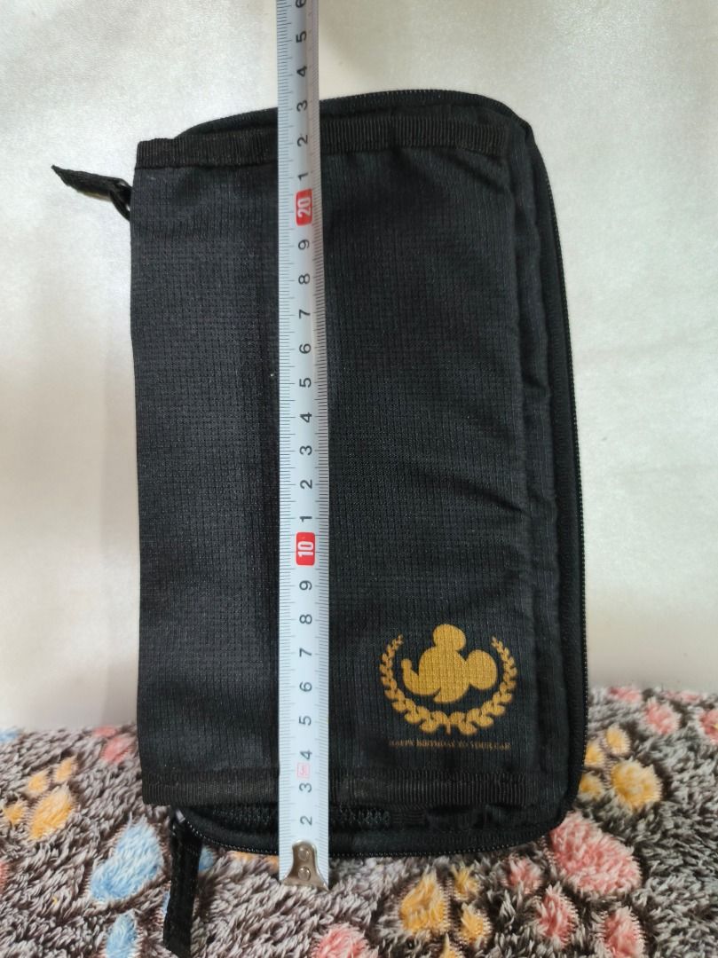 Mickey Mouse Black Organizer Pouch (Category: Purses & Pouches) located in San Leonardo. Submitted by burgossanleonardo.12345 (Listing ID 1469082338, Image 2). Description: - Stylish black multi-compartment pouch with gold Mickey Mouse silhouette logo - Compact size measuring approximately 21 cm x 12 cm - Organized interior with clear plastic pockets, zippered compartments, and mesh slots - Convenient elastic holders ideal for cards, stationery, 