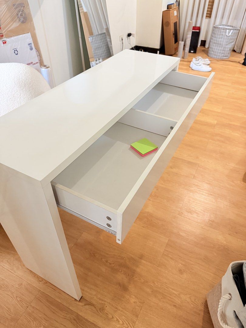 Minimalist White Study Desk with Drawer (Category: Tables & Sets) located in Taguig. Submitted by boxedgoodies (Listing ID 1469157291, Image 3). Description: - Minimalist white desk with a clean, glossy tabletop and wide flat panel legs - Built-in wide pull-out drawer with inner dividers for stationery or makeup - Solid, sturdy structure ideal for modern home offices or study rooms - Condition: Great overall look with one minor scratch near the b