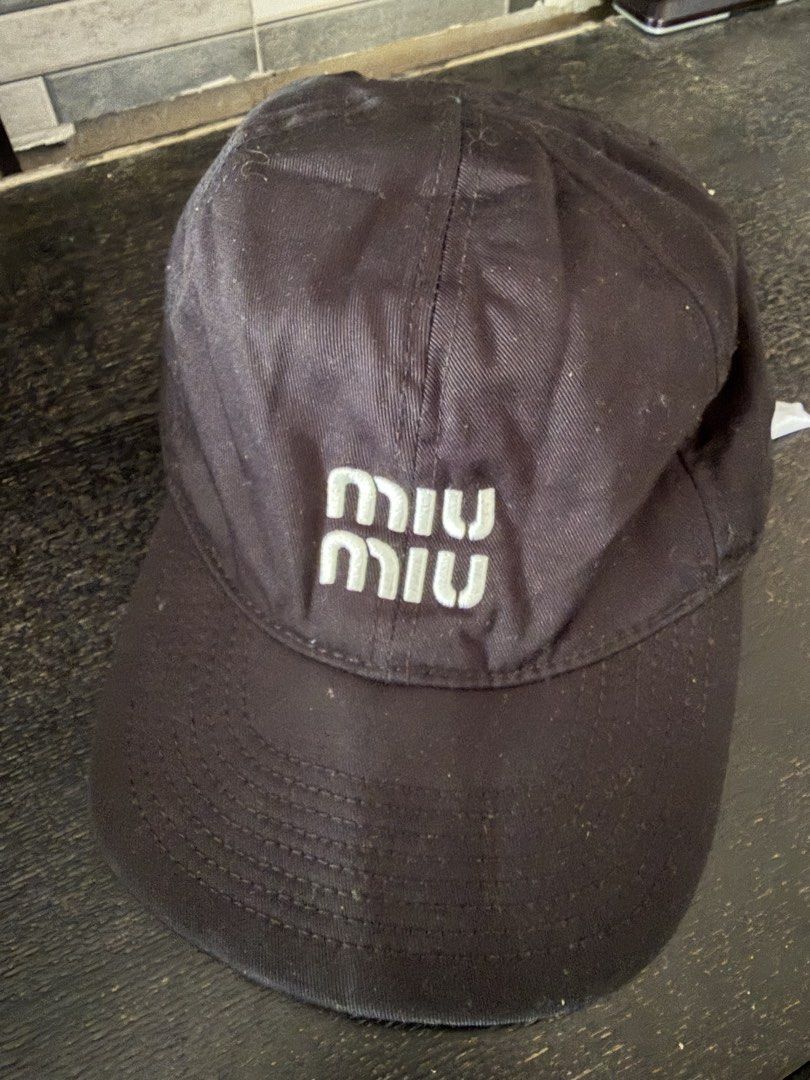Miu Miu Black Cap with Green Cord (Category: Caps & Hats) located in Manila. Submitted by trif21 (Listing ID 1468936296, Image 1). Description: - Authentic Miu Miu baseball cap in classic black - Features signature embroidered logo on the front - Stylish adjustable green and white cord detail at the back - Branded gold-tone hardware for a luxury touch - Interior tag intact - Normal wear on fabric, overall still in great pre-loved condition.