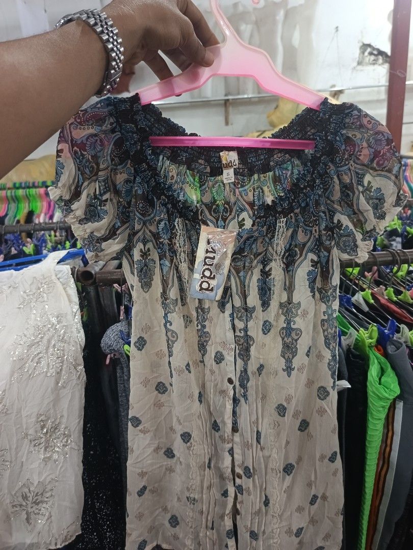 Mudd Boho Paisley Print Off-The-Shoulder Blouse (Category: Blouses) located in Tukuran. Submitted by coyythrift (Listing ID 1469073968, Image 1). Description: - Brand: Mudd (Tag still attached) - Size: Small - Design: Beige with blue, green, and brown paisley pattern - Style: Off-the-shoulder smocked neckline with short puff sleeves - Details: Button-down front with delicate lace trim - Fabric: Lightweight and comfortable.