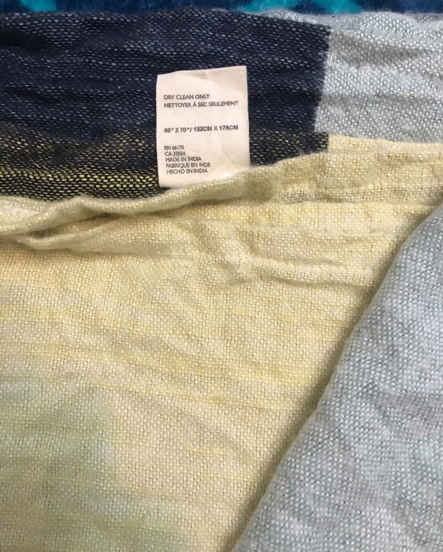 Multicolor Woven Throw Blanket (Category: Bedding & Towels) located in Imus. Submitted by stop_shop7 (Listing ID 1468959418, Image 3). Description: - Multi-colored striped throw blanket with stylish fringe edges - Made in India from a soft cotton and viscose blend - Generous size: 60 x 70 inches - Beautiful, vibrant colors perfect for draping over a sofa or chair - Care instructions: Dry clean only - Flaws: Features a small repair patch and snag 
