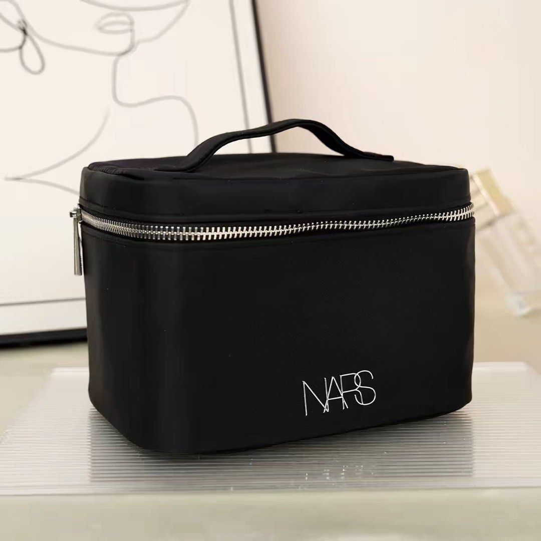 NARS Black Vanity Makeup Case Travel Pouch (Category: Purses & Pouches) located in Taguig. Submitted by mengxir20193848 (Listing ID 1469076948, Image 1). Description: - Brand: NARS - Color: Classic black with white logo and silver hardware - Design: Sturdy structured shape with a convenient top handle and wide-opening zipper - Storage: Roomy main compartment that easily fits travel bottles, plus an interior slip pocket - Condition: Brand new / Ex