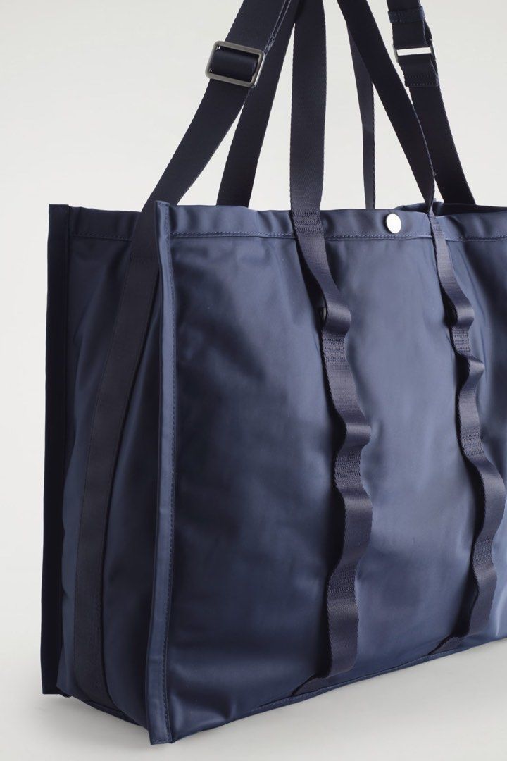Navy Blue Nylon Tote Bag with Webbed Straps (Category: Luxury Bags & Wallets) located in Manila. Submitted by pikkathchu (Listing ID 1469014407, Image 2). Description: - Color: Navy blue - Material: Lightweight and durable nylon - Design: Very spacious with clean lines - Handles: Sturdy webbed carry handles and adjustable shoulder straps - Pockets: Convenient small front pocket for quick access items - Closure: Top snap button closure - Condition