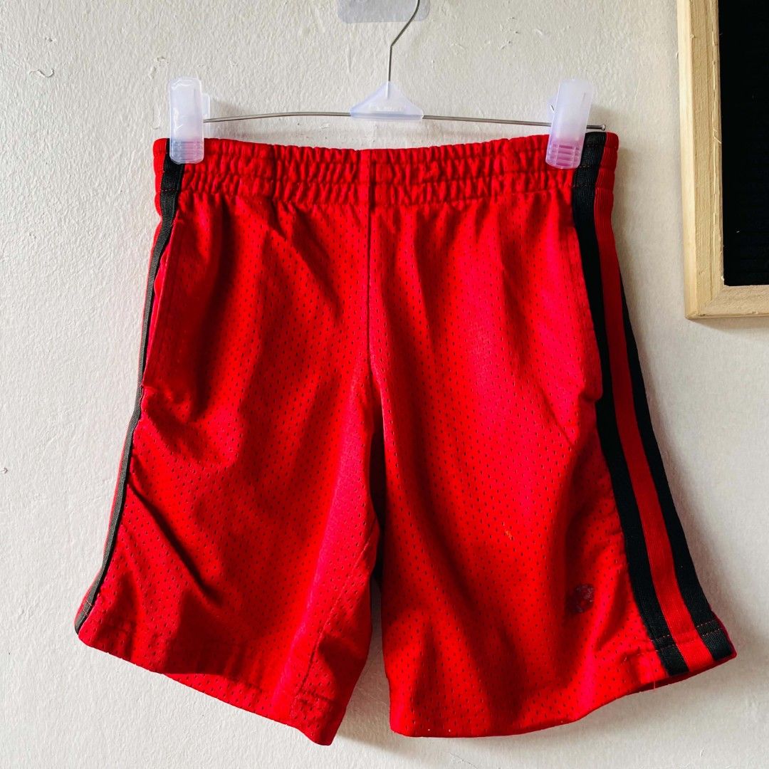 New Balance Red Mesh Shorts (Category: Babies & Kids Fashion) located in San Mateo. Submitted by safeearth21 (Listing ID 1468951060, Image 2). Description: - Brand: New Balance - Color: Bright red with black side stripes - Size: 4 (fits ages 4-5 years old) - Material: 100% breathable polyester - Features: Easy pull-on elastic waistband - Condition: Great for active play, sports, and everyday wear.