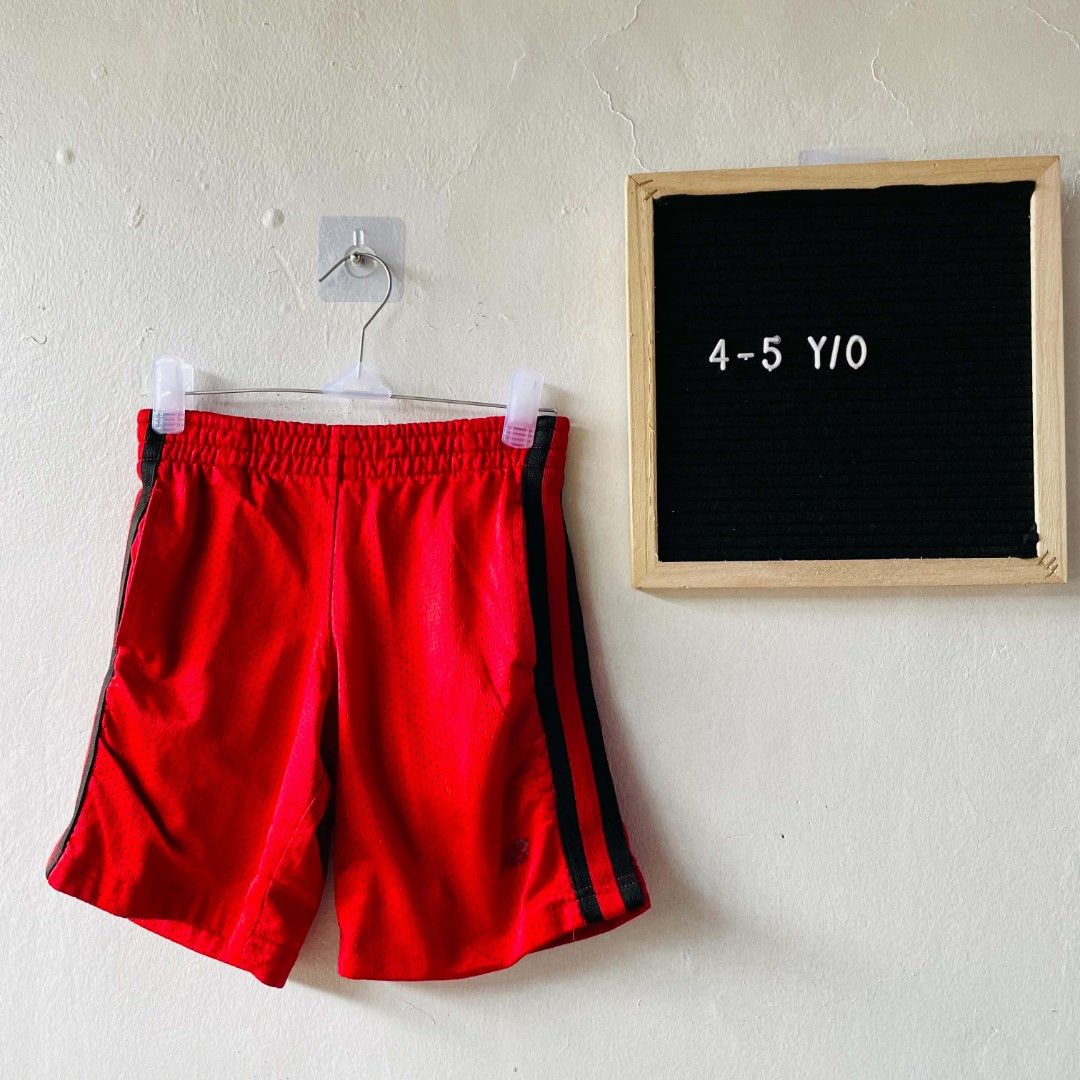New Balance Red Mesh Shorts (Category: Babies & Kids Fashion) located in San Mateo. Submitted by safeearth21 (Listing ID 1468951060, Image 1). Description: - Brand: New Balance - Color: Bright red with black side stripes - Size: 4 (fits ages 4-5 years old) - Material: 100% breathable polyester - Features: Easy pull-on elastic waistband - Condition: Great for active play, sports, and everyday wear.