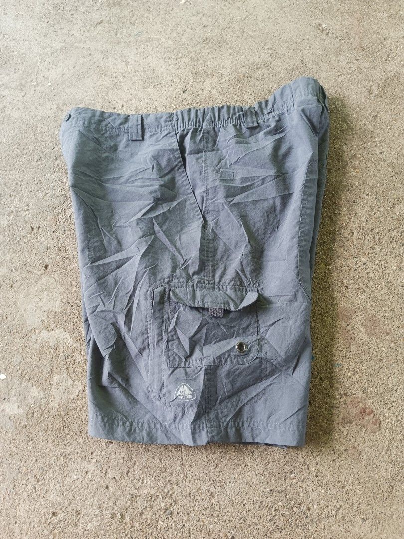 Nike ACG Grey Cargo Shorts Size M (Category: Shorts) located in Manila. Submitted by anjo1 (Listing ID 1468993910, Image 2). Description: - Brand: Nike ACG - Item: Nylon cargo shorts - Color: Grey - Size: Medium - Material: 100% polyester (Made in India) - Waistband: Elastic with button closure - Features: Multiple utility pockets with Nike ACG logo prints - Condition: Great outdoor gear, perfect for hiking or casual wear.