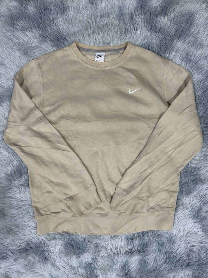 Nike Beige Crewneck Sweatshirt (Category: Coats, Jackets and Outerwear) located in Manila. Submitted by gemfinds650 (Listing ID 1469027780, Image 1). Description: - Brand: Nike - Style: Classic crewneck pullover - Color: Versatile beige - Details: Small embroidered white swoosh logo on the chest - Comfort: Soft fleece interior for extra warmth - Fit: Standard fit with ribbed cuffs and hem.