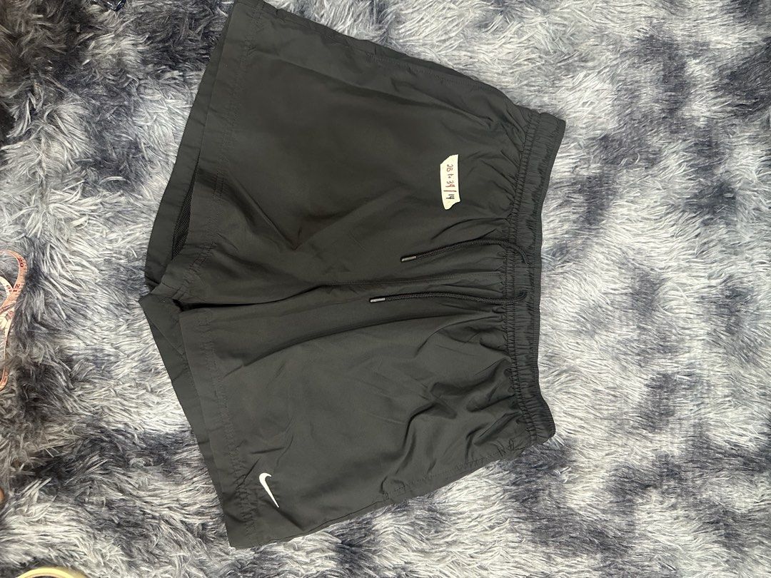 Nike Black Athletic Shorts with Drawstring (Category: Shorts) located in Quezon City. Submitted by nichole12 (Listing ID 1469090817, Image 2). Description: - Brand: Nike - Color: Classic Black - Style: Lightweight athletic shorts - Waistband: Elastic with adjustable black drawstring - Branding: Small white embroidered Nike swoosh logo near the hem - Size/Fit: Exact measurements are indicated on the attached sticker tag in the photos - Condition: 