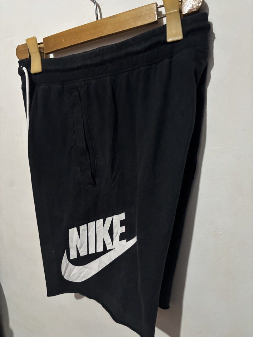 Nike Black Shorts with White Logo and Drawstring (Category: Shorts) located in Subic. Submitted by thriftpoison (Listing ID 1469149341, Image 2). Description: - Color: Classic black with a big white Nike logo print - Fit & Comfort: Elastic waistband with white drawstring cords and trendy raw edge hem - Pockets: Two practical side pockets plus one back pocket with a signature red logo tab - Versatility: Ideal for casual wear, workouts, or everyday