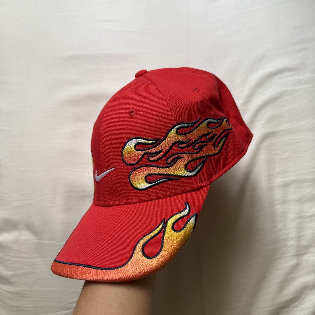 Nike Club Structured OG Flame Cap (Category: Caps & Hats) located in Pasig City. Submitted by notshynotmeee (Listing ID 1468960780, Image 2). Description: - Brand: Nike - Color: Bold red with yellow, orange, and white embroidered flames - Logos: White Nike swoosh on the front, mini swoosh on the adjustable strapback - Design: Structured fit with flames wrapping around the sides and brim - Condition: Clean structure with vivid colors Clean, never 