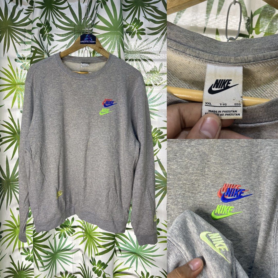 Nike Crewneck (Category: Coats, Jackets and Outerwear) located in Caloocan City. Submitted by thriftywaps (Listing ID 1468937607, Image 1). Description: - Brand: Nike - Style: Crewneck Sweatshirt - Color: Grey - Size: XXL - Details: Stacked embroidered multi-color logos (red, blue, lime green) on the chest, lower right front, and left sleeve cuff - Origin: Made in Pakistan - Condition: Good overall, with minor dirt marks near the tag/collar.