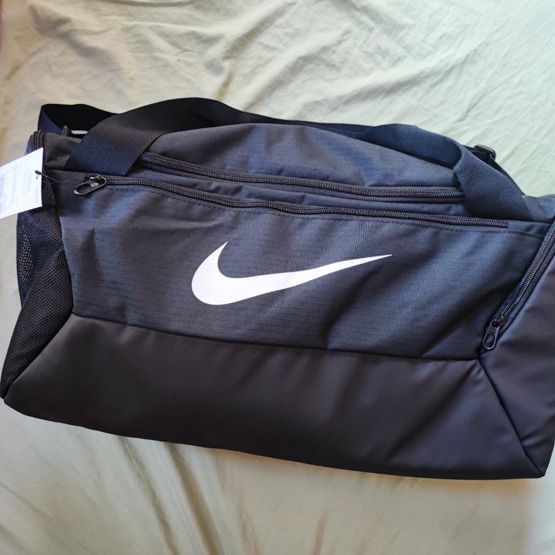 Nike Duffel Bag Black 41L (Category: Backpacks) located in Taytay. Submitted by ampolalay (Listing ID 1469069805, Image 1). Description: - Brand: Nike - Color: Black with large white swoosh - Capacity: 41 liters - Condition: Brand new with original retail tags attached - Material: Durable fabric construction - Storage: Multiple zipped compartments and convenient mesh side pocket - Details: Custom branded zipper pulls.