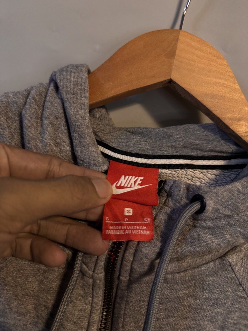 Nike Gray Zip Up Hoodie Size S (Category: Hoodies) located in Alaminos. Submitted by outfitcheck.ph (Listing ID 1469103217, Image 3). Description: - Brand: Nike - Style: Zip-up hoodie with drawstrings and split kangaroo pockets - Size: Small - Color: Gray with black Nike logo on the upper left chest - Material: 83% cotton, 17% polyester (Made in Vietnam) - Features: Ribbed cuffs and hem - Condition: Clean overall, ready to wear.