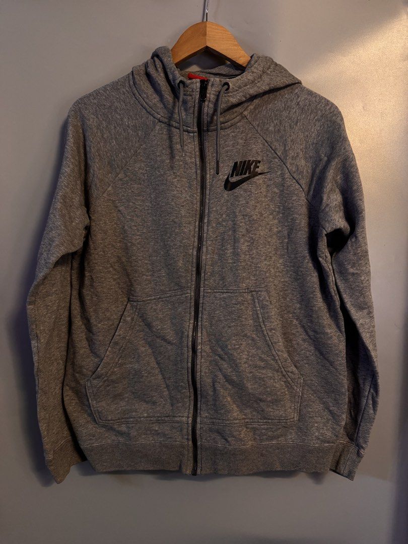Nike Gray Zip Up Hoodie Size S (Category: Hoodies) located in Alaminos. Submitted by outfitcheck.ph (Listing ID 1469103217, Image 1). Description: - Brand: Nike - Style: Zip-up hoodie with drawstrings and split kangaroo pockets - Size: Small - Color: Gray with black Nike logo on the upper left chest - Material: 83% cotton, 17% polyester (Made in Vietnam) - Features: Ribbed cuffs and hem - Condition: Clean overall, ready to wear.