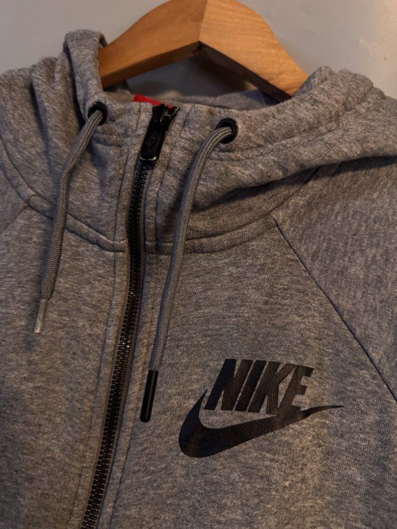 Nike Gray Zip Up Hoodie Size S (Category: Hoodies) located in Alaminos. Submitted by outfitcheck.ph (Listing ID 1469103217, Image 2). Description: - Brand: Nike - Style: Zip-up hoodie with drawstrings and split kangaroo pockets - Size: Small - Color: Gray with black Nike logo on the upper left chest - Material: 83% cotton, 17% polyester (Made in Vietnam) - Features: Ribbed cuffs and hem - Condition: Clean overall, ready to wear.
