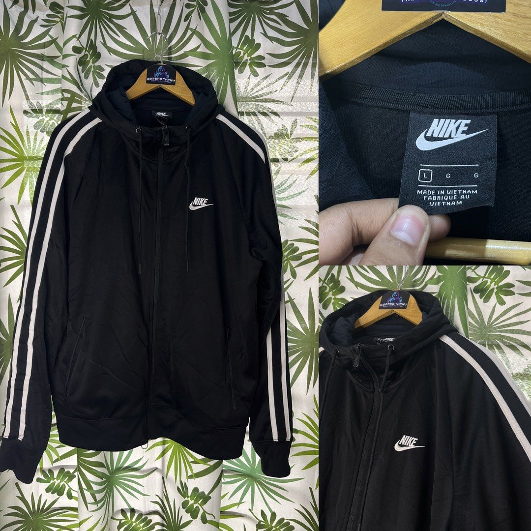 Nike hoodie (Category: Hoodies) located in Caloocan City. Submitted by thriftywaps (Listing ID 1468937187, Image 1). Description: Black Nike zip-up hoodie. White double stripes run down both sleeves. Small white Nike logo embroidered on the left chest. Includes an adjustable drawstring hood and two side pockets. Tag says size L, made in Vietnam. Clean condition inside and out..