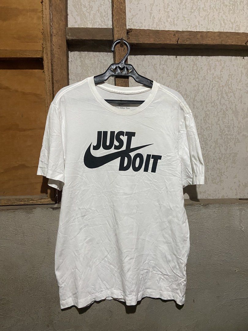 Nike Just Do It White T-Shirt Size L (Category: Shirts) located in Cagayan de Oro. Submitted by mindanao_thrifters (Listing ID 1468944678, Image 1). Description: - Brand: Nike - Color: White with large black 'Just Do It' graphic - Size: Large (Standard Fit) - Material: 100% Cotton - Style: Classic crew neck, short sleeve - Origin: Made in China - Condition: Excellent, easy to style with shorts or jeans.