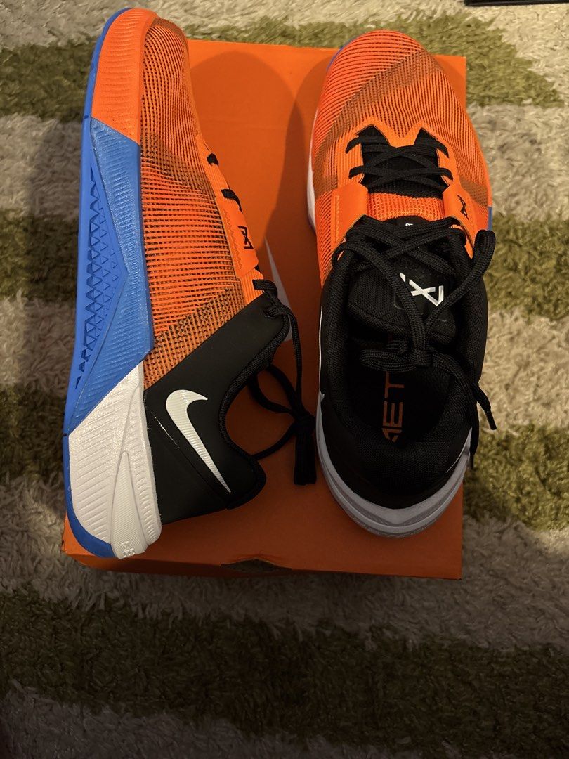 Nike Metcon 10 Training Shoes Orange Blue (Category: Sneakers) located in Pasig City. Submitted by ripescobar (Listing ID 1469016675, Image 1). Description: - Brand: Nike - Type: Training shoes - Color: Bright orange mesh upper with black accents and white swoosh - Soles: Blue and white rubber soles for maximum grip during lifts and workouts - Laces: Black - Inclusion: Original orange Nike shoebox included - Condition: Brand New.