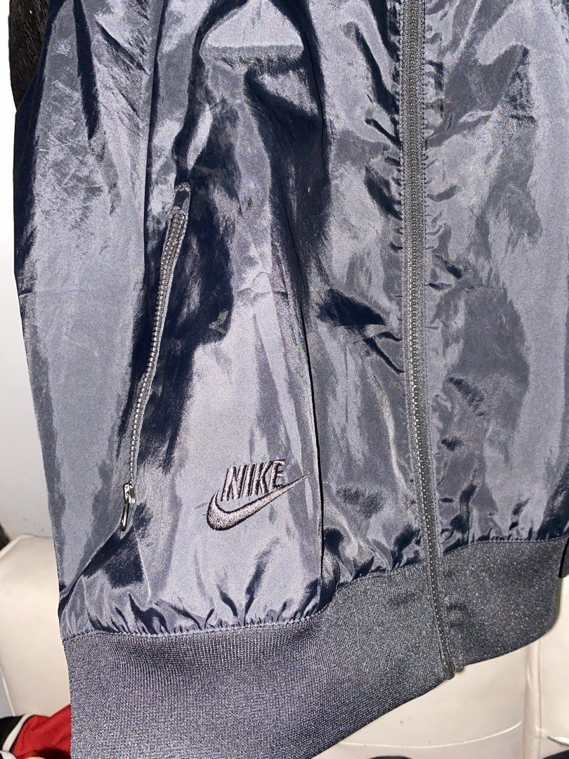 Nike Multiple Logo Windbreaker Black Large (Category: Coats, Jackets and Outerwear) located in Manila. Submitted by japhetcond32104 (Listing ID 1469111349, Image 3). Description: - Brand: Nike - Item: Windbreaker Jacket - Color: Black - Size: Large (on tag) - Design: Multiple stacked logos on the chest and lower hem - Features: Full zip front, adjustable hood with drawstrings, ribbed cuffs and hem, and secure zippered side pockets - Condition: Ex