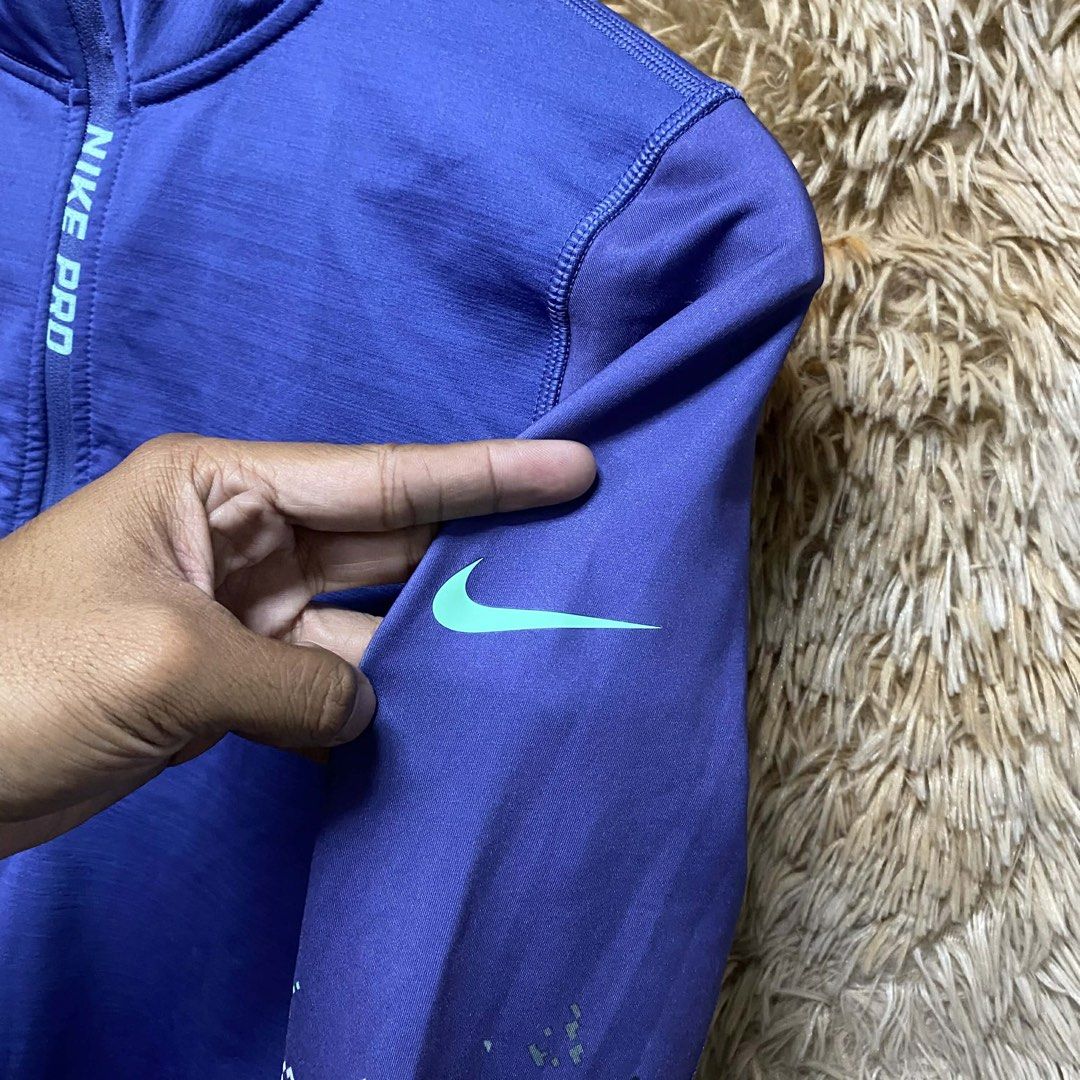 Nike Pro Purple Half-Zip Long Sleeve Workout Top (Category: Activewear) located in Butuan. Submitted by jc13thrifts (Listing ID 1469064230, Image 2). Description: - Brand: Nike Pro - Style: Half-zip long sleeve top with mock neck - Color: Purple with mint green logo and vertical front branding - Details: Pixelated camo pattern on forearms (green, grey, purple, white) - Ideal for: Running, gym workouts, and sporty casual outfits.
