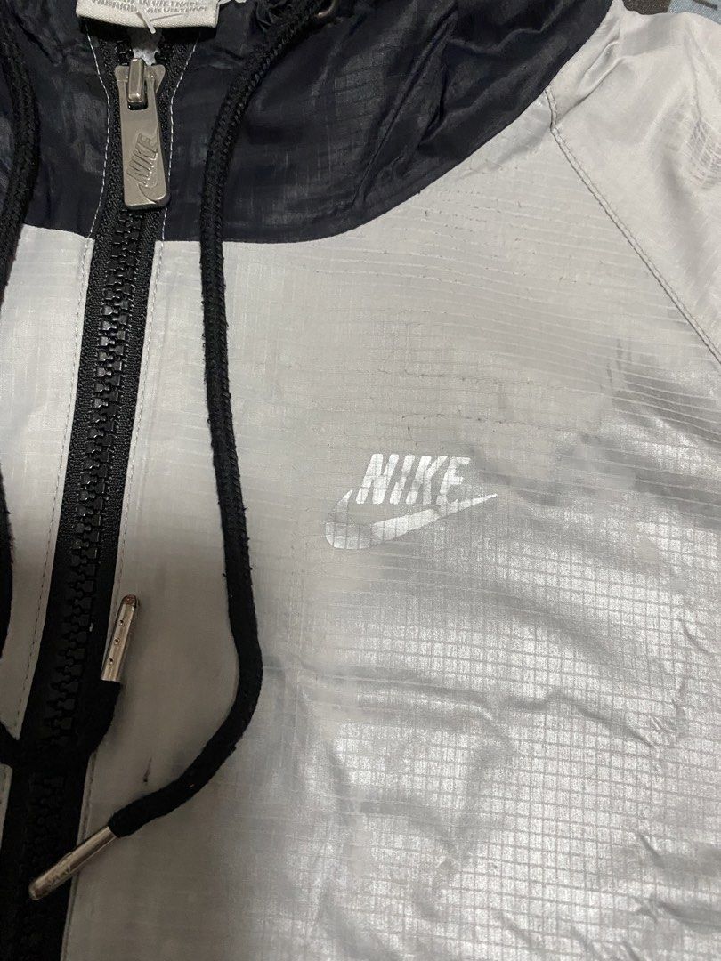 Nike Sportswear Windrunner Hooded Jacket Silver Black (Category: Coats, Jackets and Outerwear) located in Taguig. Submitted by maaarrrrrcky (Listing ID 1469012405, Image 2). Description: - Brand/Model: Nike Sportswear Windbreaker Jacket - Colorway: Silver and Black - Size: Medium (M) - Country of Origin: Vietnam - Material: Lightweight ripstop with grid pattern texture - Features: Full zip closure, drawstring hood, elasticated cuffs, and zipped s
