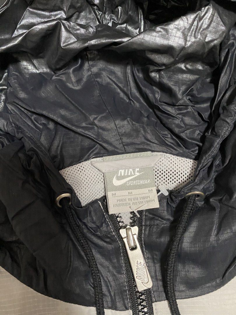 Nike Sportswear Windrunner Hooded Jacket Silver Black (Category: Coats, Jackets and Outerwear) located in Taguig. Submitted by maaarrrrrcky (Listing ID 1469012405, Image 3). Description: - Brand/Model: Nike Sportswear Windbreaker Jacket - Colorway: Silver and Black - Size: Medium (M) - Country of Origin: Vietnam - Material: Lightweight ripstop with grid pattern texture - Features: Full zip closure, drawstring hood, elasticated cuffs, and zipped s