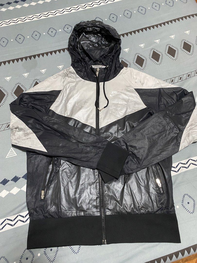 Nike Sportswear Windrunner Hooded Jacket Silver Black (Category: Coats, Jackets and Outerwear) located in Taguig. Submitted by maaarrrrrcky (Listing ID 1469012405, Image 1). Description: - Brand/Model: Nike Sportswear Windbreaker Jacket - Colorway: Silver and Black - Size: Medium (M) - Country of Origin: Vietnam - Material: Lightweight ripstop with grid pattern texture - Features: Full zip closure, drawstring hood, elasticated cuffs, and zipped s