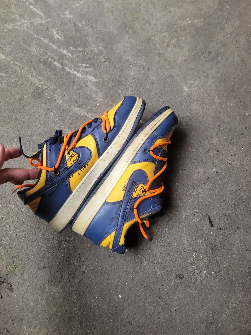 Nike x Off-White Dunk Low Michigan (Category: Sneakers) located in Caloocan City. Submitted by remwil18 (Listing ID 1468934431, Image 2). Description: - Item: Nike Dunk Low x Off-White (Michigan Colorway) - Size: US 7.5 / UK 7 / EUR 40 / JP 250 - Features: Blue and yellow leather upper, iconic secondary orange lacing system, and signature Off-White medial text branding - Condition: Pre-owned collector pair with scuffs on the outer material and di