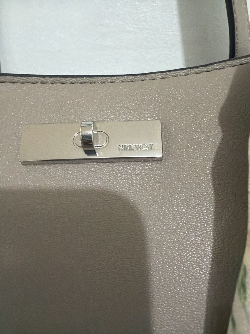 Nine West Harmon Handbag Tote (Category: Tote Bags) located in Quezon City. Submitted by wildeagle-cf48 (Listing ID 1468955639, Image 3). Description: - Nine West Harmon Handbag Tote in Pumice - Details: Clean stitching with silver-tone center hardware - Accessory: Includes a detachable ribbon - Capacity: Roomy interior that easily fits everyday essentials - Versatility: Neutral color matches effortlessly with any outfit.