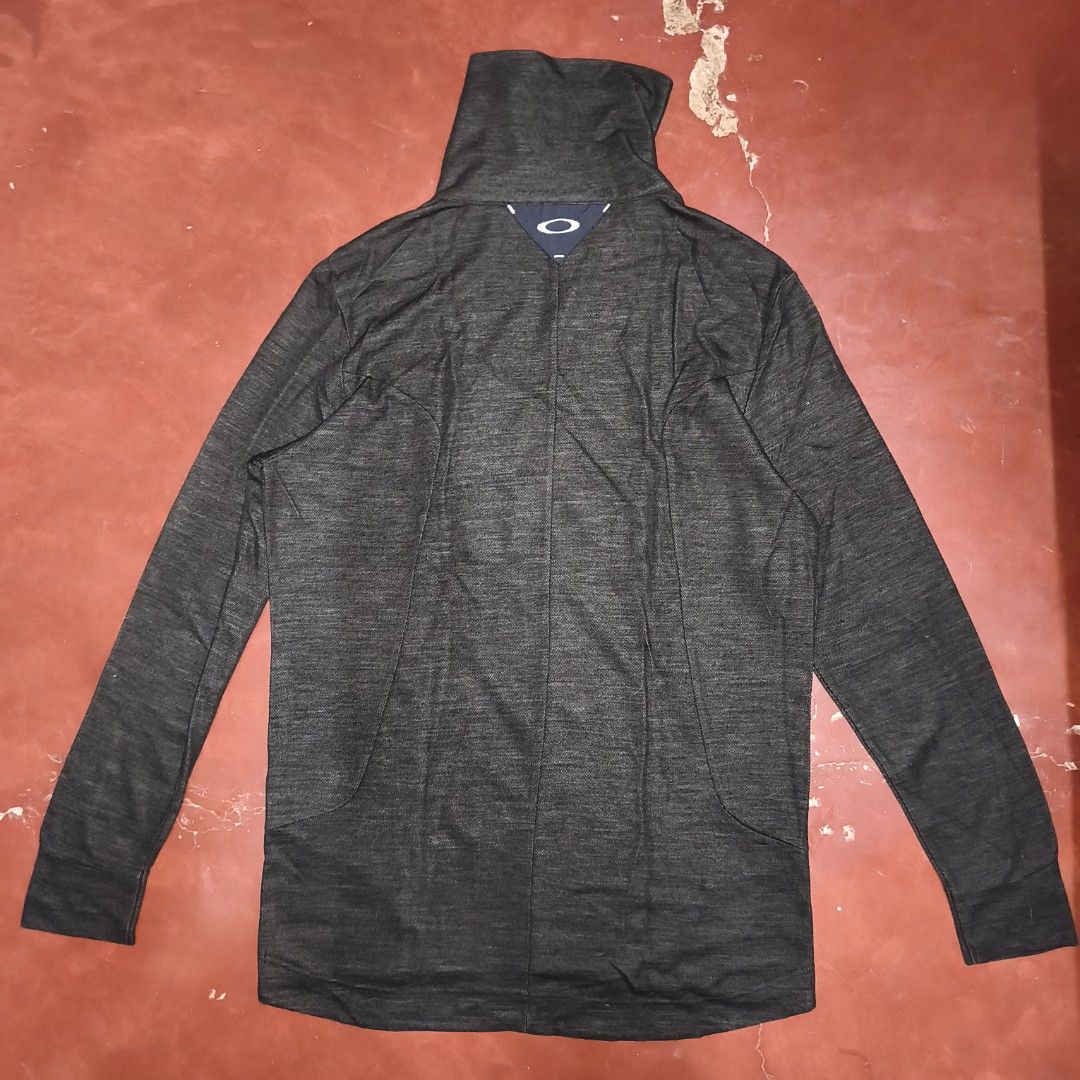 Oakley Charcoal Grey Funnel Neck Pullover Sweatshirt (Category: Coats, Jackets and Outerwear) located in Antipolo. Submitted by alphaomega_fox (Listing ID 1469024603, Image 2). Description: - Brand: Oakley -size: 20x28 - Style: Pullover with funnel neck and snap button closure - Color: Dark grey heather with contrast navy chest pocket - Pockets: 1 zippered chest pocket with small logo tag - Branding: White Oakley ellipse logo near bottom hem and 