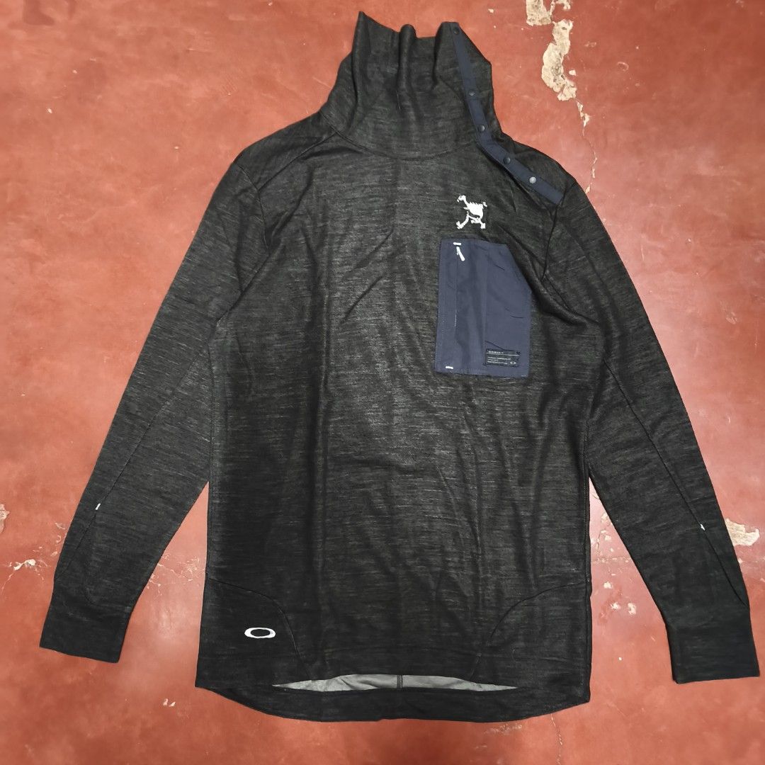 Oakley Charcoal Grey Funnel Neck Pullover Sweatshirt (Category: Coats, Jackets and Outerwear) located in Antipolo. Submitted by alphaomega_fox (Listing ID 1469024603, Image 1). Description: - Brand: Oakley -size: 20x28 - Style: Pullover with funnel neck and snap button closure - Color: Dark grey heather with contrast navy chest pocket - Pockets: 1 zippered chest pocket with small logo tag - Branding: White Oakley ellipse logo near bottom hem and 