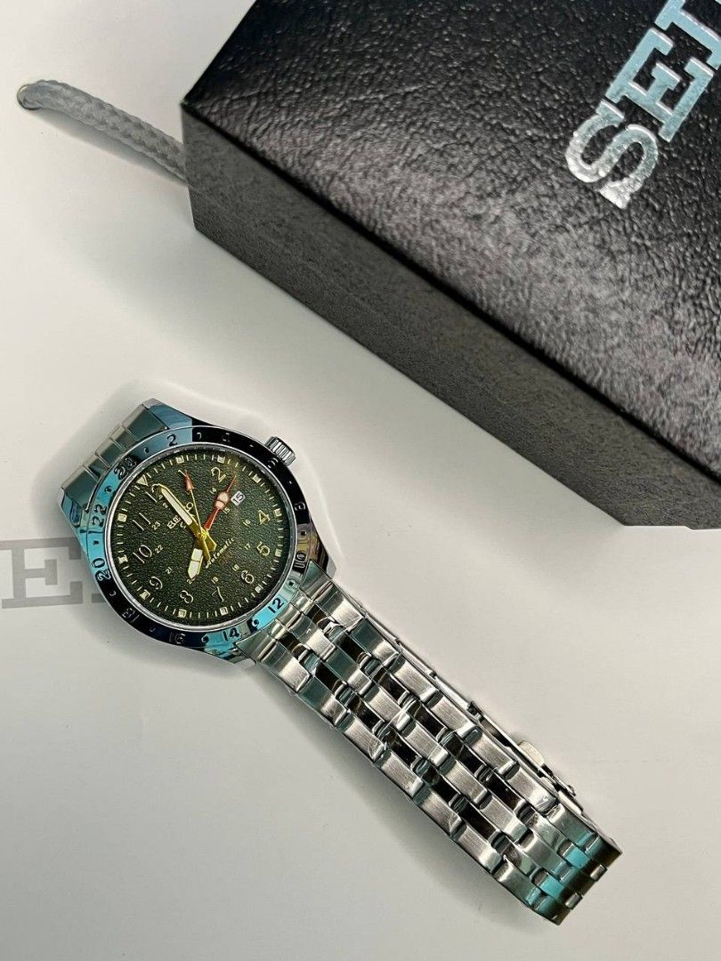 OEM WATCH ONLY‼️ (Category: Men's Watches) located in Manila. Submitted by seannathan46011 (Listing ID 1469070666, Image 3). Description: Selling an authentic Seiko 5 Sports Field GMT automatic watch featuring an olive green textured dial, bold Arabic numerals, and a vibrant yellow GMT hand. Encased in durable stainless steel with a matching multi-row bracelet and signed clasp. Comes with the original Seiko box. Perfect everyday automatic watch f