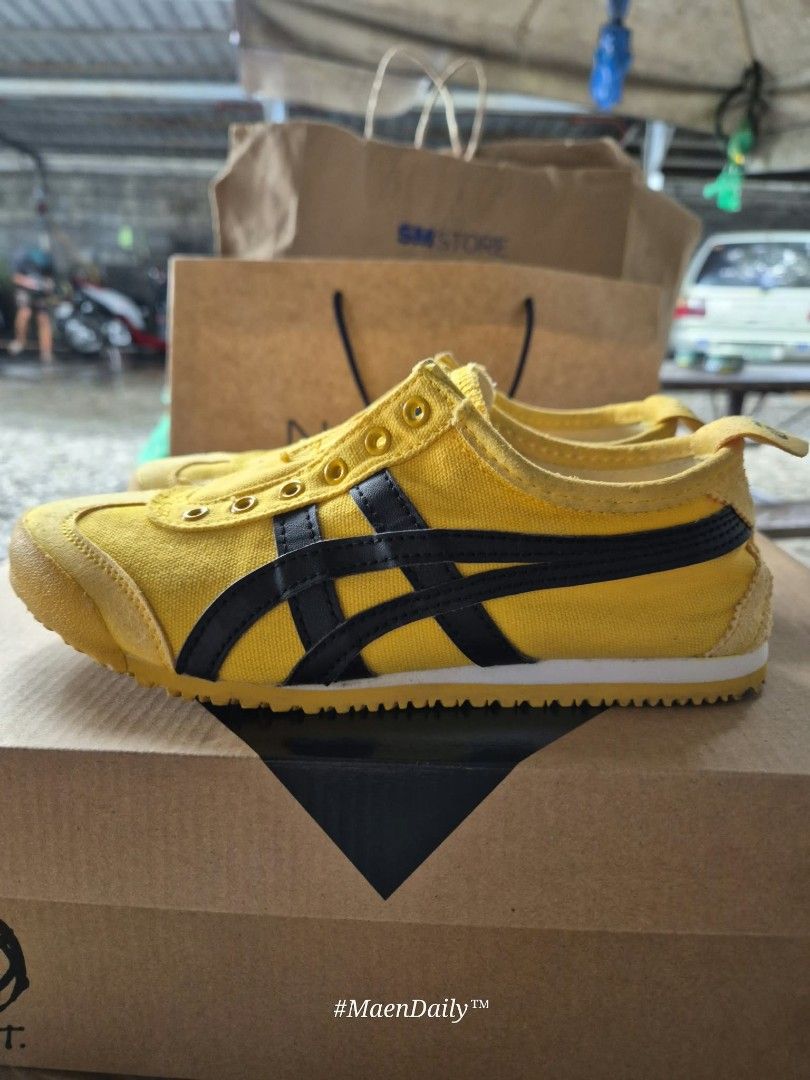 Onitsuka Tiger Yellow Black Sneakers (Category: Sneakers) located in Santo Tomas. Submitted by anneiyayey (Listing ID 1468980173, Image 2). Description: - Brand: Onitsuka Tiger - Style: Classic low-top slip-on sneakers (no laces) - Colorway: Striking yellow and black with signature side stripes - Soles: Yellow rubber outsoles with great tread grip remaining - Condition: Clean interior linings; minor normal wear and slight discoloration on suede t