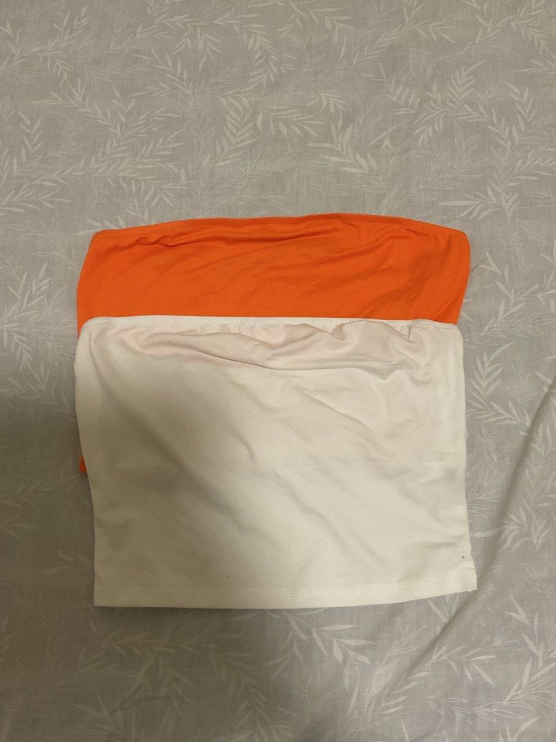 Orange and white basic strapless tube top bundle (Category: Sleeveless) located in Taytay. Submitted by prelovedbyblaire (Listing ID 1469103021, Image 1). Description: - Set of 2 basic strapless tube tops (bright orange and off-white) - Stretchy and flattering hugging fit - Ideal for layering or wearing solo in warm weather - Easy to pair with high-waisted denim or skirts - Wardrobe essentials in clean condition.