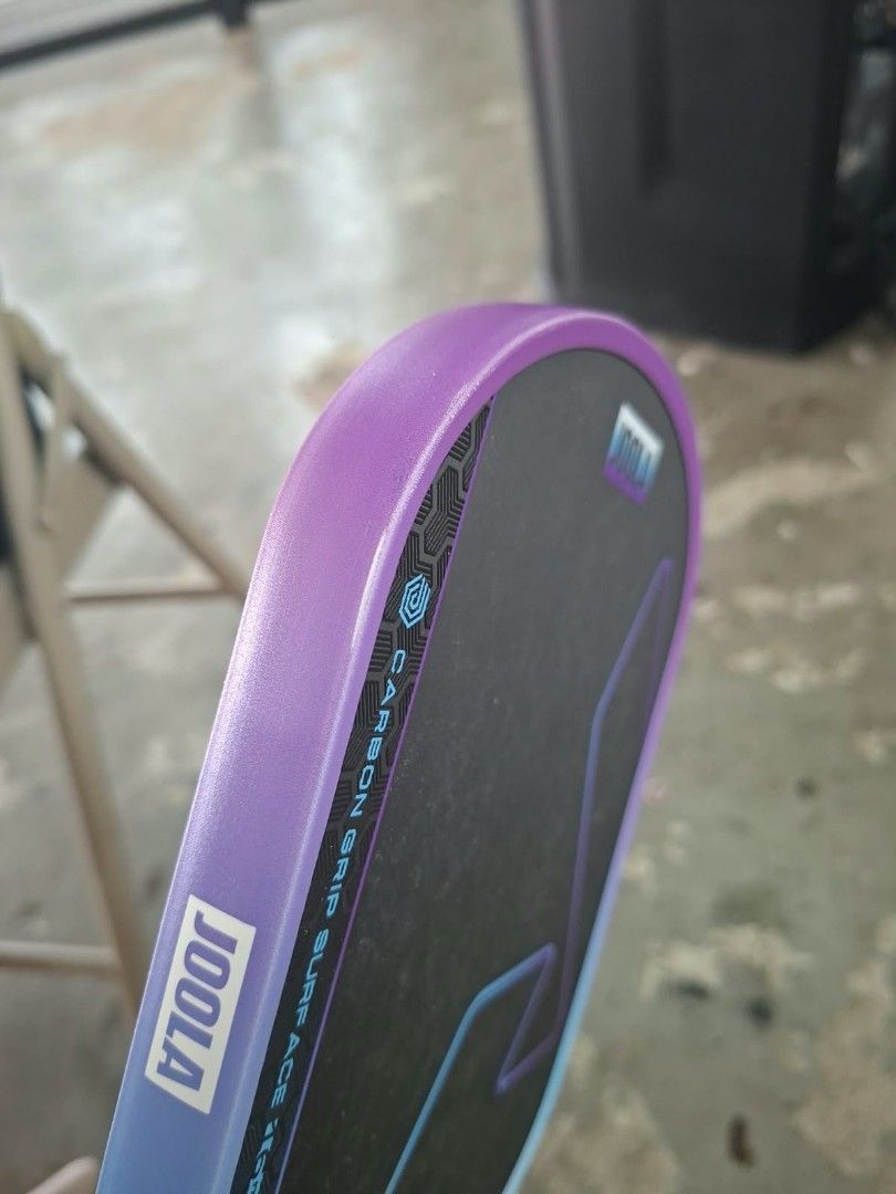 Original JOOLA Vision Pickleball Paddle (Category: Racket and Ball Sports) located in Paranaque City. Submitted by babythings (Listing ID 1469156290, Image 3). Description: - Brand: JOOLA Vision Pickleball Paddle - Design: Eye-catching purple, blue, and white gradient frame with a standard shape - Surface: Carbon grip surface for enhanced control and spin - Handle: Wrapped purple gri p with branded end cap - Certification: USA Pickleball approved