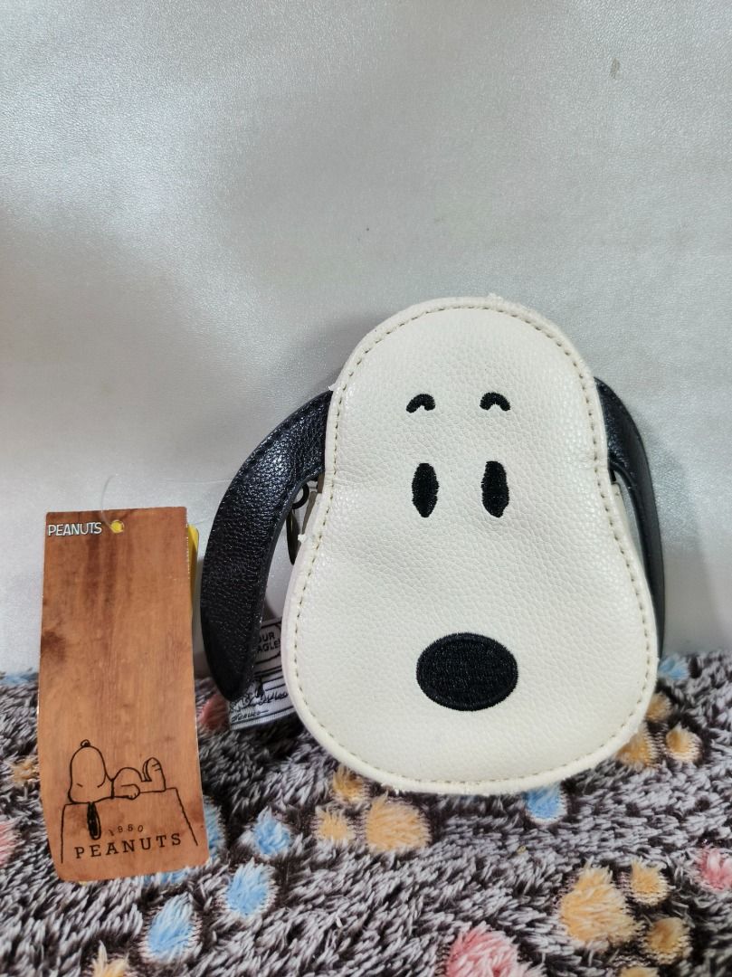 Peanuts Snoopy Face Pouch Coin Purse (Category: Purses & Pouches) located in San Leonardo. Submitted by burgossanleonardo.12345 (Listing ID 1469075442, Image 2). Description: - Authentic Peanuts merchandise with original store tags still attached - Adorable Snoopy face design with embroidered eyes, nose, and floppy ears on the front - Charlie Brown graphic and "Just Your Basic Beagle" inner tag on the back - Compact and handy size, ideal for coin
