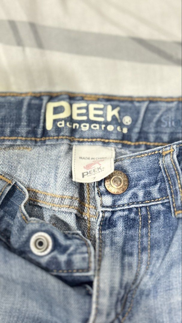 Peek Dungarees Denim Shorts Size 7 (Category: Babies & Kids Fashion) located in Lucena. Submitted by jaejae___ (Listing ID 1469107682, Image 2). Description: - Brand: Peek Dungarees - Style: Denim shorts in light blue wash - Size: Tagged size 7 - Details: Raw frayed hems, button fly with branded metallic hardware, classic five-pocket styling - Branding: Leather logo patch on back waistband - Origin: Made in China.