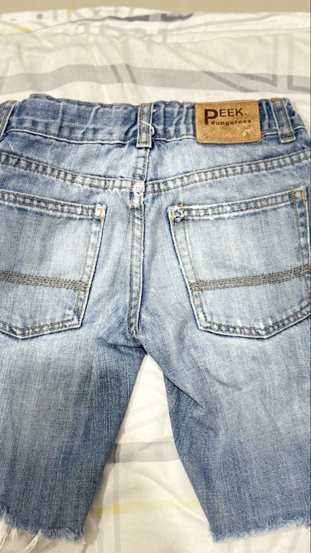Peek Dungarees Denim Shorts Size 7 (Category: Babies & Kids Fashion) located in Lucena. Submitted by jaejae___ (Listing ID 1469107682, Image 3). Description: - Brand: Peek Dungarees - Style: Denim shorts in light blue wash - Size: Tagged size 7 - Details: Raw frayed hems, button fly with branded metallic hardware, classic five-pocket styling - Branding: Leather logo patch on back waistband - Origin: Made in China.