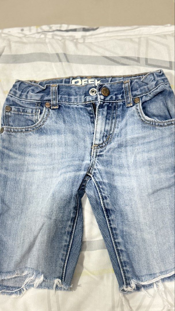 Peek Dungarees Denim Shorts Size 7 (Category: Babies & Kids Fashion) located in Lucena. Submitted by jaejae___ (Listing ID 1469107682, Image 1). Description: - Brand: Peek Dungarees - Style: Denim shorts in light blue wash - Size: Tagged size 7 - Details: Raw frayed hems, button fly with branded metallic hardware, classic five-pocket styling - Branding: Leather logo patch on back waistband - Origin: Made in China.