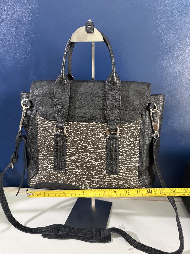 Philip Lim Pashli Leather Bag (Category: Shoulder Bags) located in Makati City. Submitted by katdestash (Listing ID 1468972404, Image 2). Description: - Color & Material: Black and white textured leather with front flap - Hardware: Silver-tone accents, front push-lock clasp, and vertical zip details to expand the bag - Carrying Options: Dual top handles plus an adjustable, detachable shoulder strap with a comfort pad - Interior/Structure: Roomy m