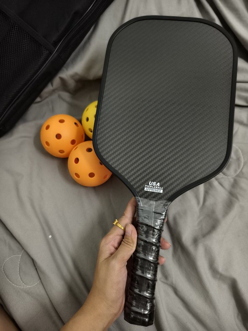 Pickleball Paddle Set with Balls and Carry Bag (Category: Racket and Ball Sports) located in Angeles City. Submitted by measaliman02351 (Listing ID 1469109491, Image 3). Description: - Complete pickleball set ready for the courts - Premium carbon fiber paddle with USA Pickleball approved stamp - Includes 4 balls in high-visibility yellow and orange - Comes with a sleek black carry bag for easy transport.