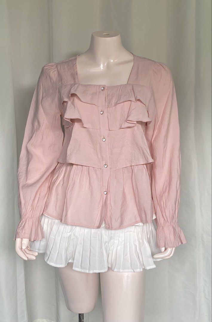 Pink Ruffle Square Neck Blouse Medium (Category: Blouses) located in Batangas. Submitted by mynne_09 (Listing ID 1469005066, Image 2). Description: - Color: Pink - Size: Medium - Neckline: Square neck - Details: Layered front ruffles, flared cuffs, and sweet heart-shaped buttons - Closure: Button-down front - Style: Super cute, pairs great with skirts - Condition: Excellent.