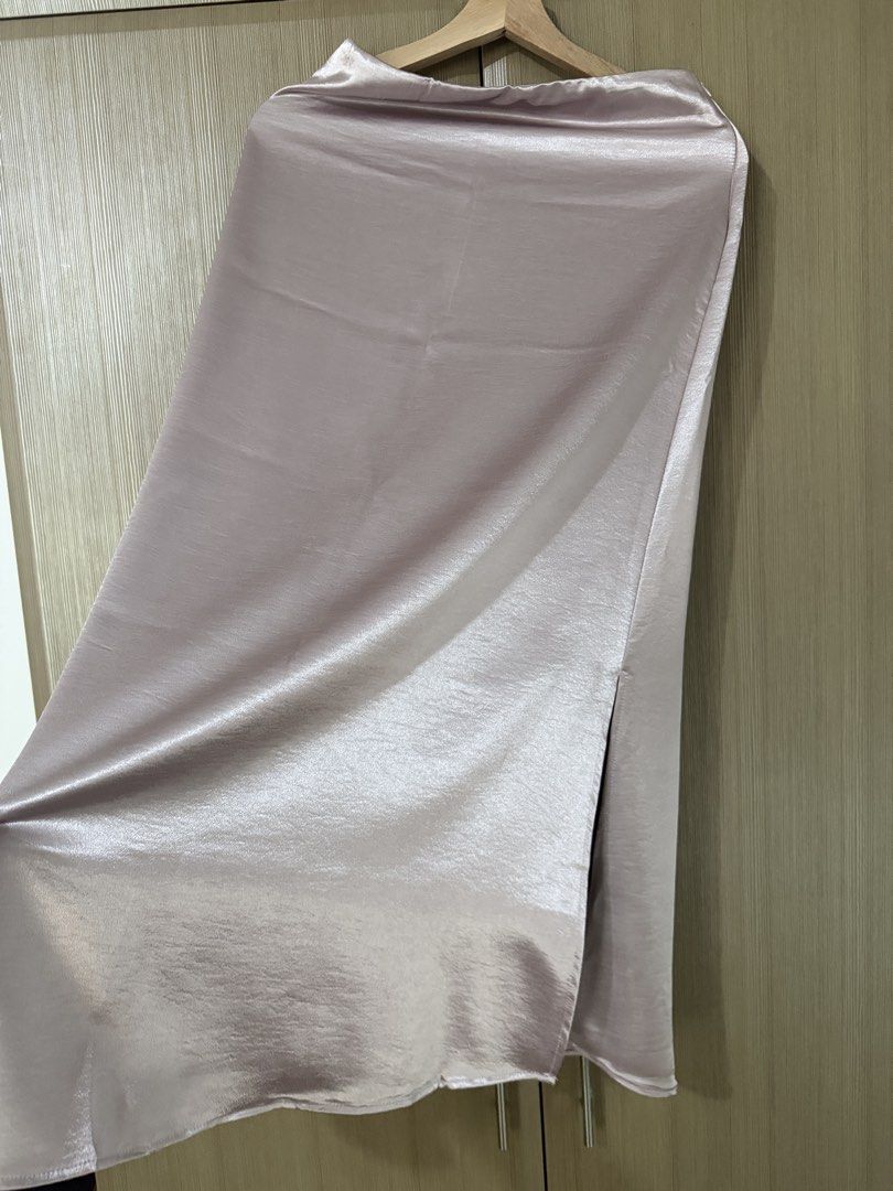 Pink Satin Midi Skirt with Side Slit (Category: Skirts) located in Taguig. Submitted by mengxir20193848 (Listing ID 1468988900, Image 3). Description: - Color: Light pink - Material: Smooth, glossy satin with a lovely drape - Fit: High-waisted with a comfortable elastic waistband - Design: Chic side slit for easy movement - Condition: Clean, no flaws noticed - Styling: Perfect for both casual daytime looks and dressed-up evenings.